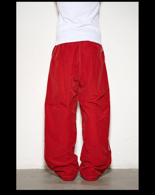 NOVACAM Logo Embroidered Nylon Curved Baggy Track Pants | Face 3 Face